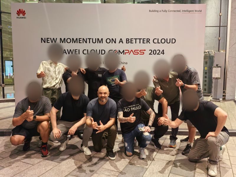 Grupo de participantes brasileiros em frente ao painel do Huawei Cloud Compass 2024